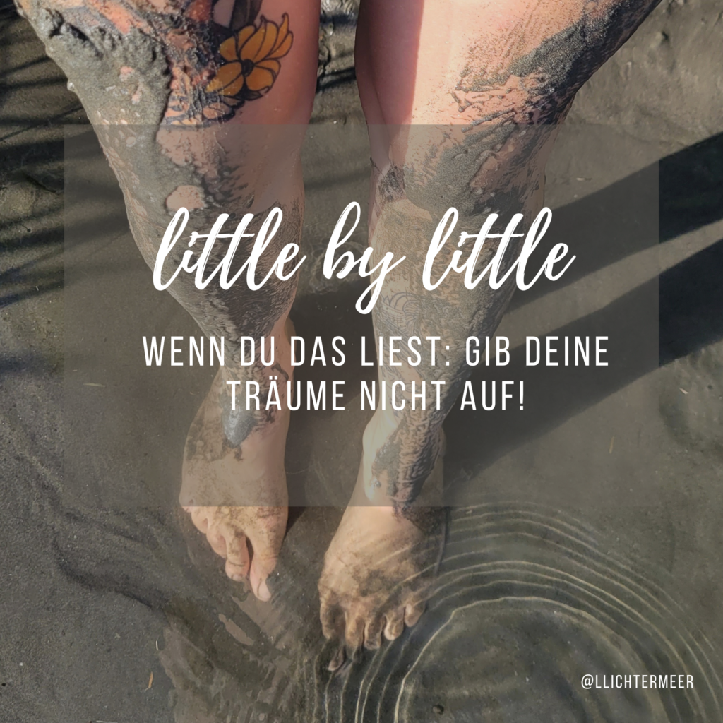 Tätowierte Frauenbeine mit Sand und Matsch verschmiert und den Füßen im Flusswasser als Symbol für Erdung, Getragen-sein und Kraftsammeln. Dazu die Worte: little by little: wenn du das liest, gib deine Träume nicht auf!