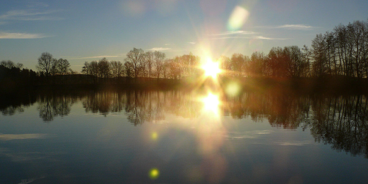 Foto von einem Sonnenuntergang am Wasser. Die Sonne sieht wie Sterne aus. Symbol für die energetische Heilarbeit von Llichtermeer